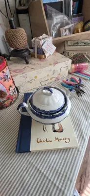 Sale Photo Thumbnail #88: Vintage blue and white porcelain tureen resting on a Charlie Mackesy book, surrounded by craft supplies and decorative tins.