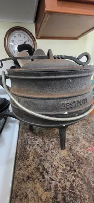 Sale Photo Thumbnail #79: Vintage BestDuty three-legged cast iron potjie pot with lid and bail handle, showing light surface wear and patina.