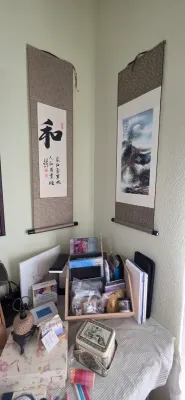Sale Photo Thumbnail #87: Pair of traditional East Asian wall scrolls hung in a room corner, displayed above an assortment of crafting supplies and decorative tins.