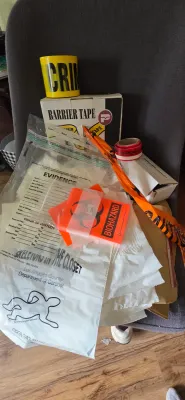 Sale Photo Thumbnail #97: Collection of crime scene theme novelties and supplies, including yellow barrier tape, biohazard stickers, red evidence tape, and plastic evidence bags.