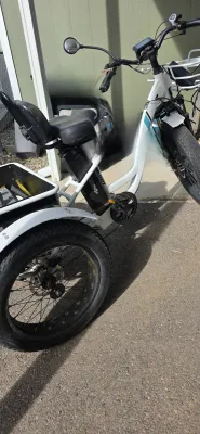 Sale Photo Thumbnail #38: White electric fat-tire tricycle featuring a padded seat with a backrest, front and rear cargo baskets, and a side mirror.