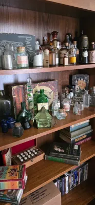 Sale Photo Thumbnail #107: Wooden bookcase filled with vintage and antique apothecary bottles, potion boxes, glassware, books, and curiosities.