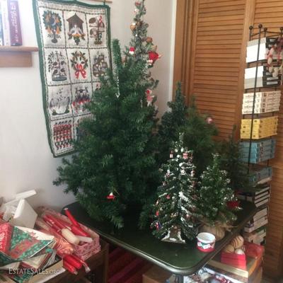 Collection of small artificial Christmas trees. Some have ornaments and some do not