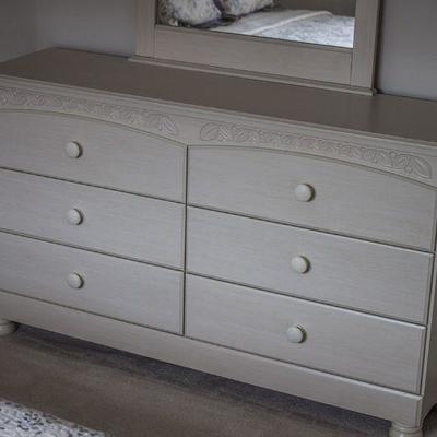 Soft-white (linen), queen three piece bedroom set by Design by Ashley with headboard, bedside table, and dresser with mirror.