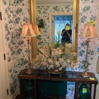 outstanding mirror, glass top console table stately lamps and a pair of decorative ginger jars. 