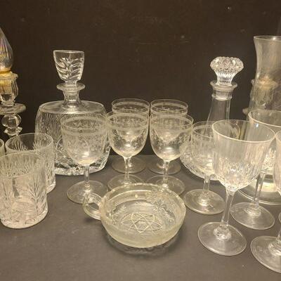20 pieces of dishes. Six glasses with an ivy design, four wine glasses, four glasses, a small candy dish, two decanters, a candle holder...