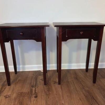 A matching set of wood end tables with single pull out draw with wood knob accents. The surfaces show signs of wear on both tables....