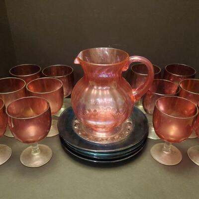 Set of 12 heavy purple glass goblets with clear stems are 6" tall. Pitcher is 8" tall, it is plastic but it matches the set...