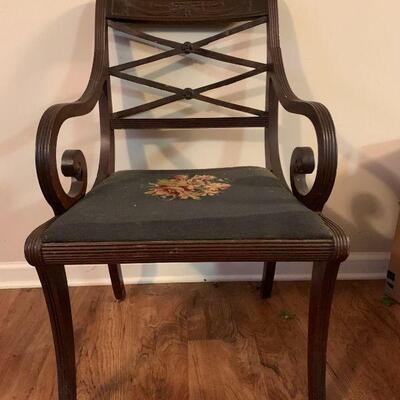 This is an Antique looking wooden chair with decorative scroll woodwork and artistic flourishes throughout, there is a floral design done...