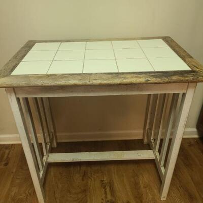 White tile framed in wood frame with wooden legs painted white. Measures 36" x 24" x 34"....