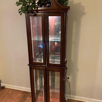 This is a Cherry and glass curio cabinet by Amelia. It has a top light with rolled toggle switch that is in working order. There is one...