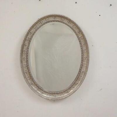 1018	BEVELED GLASS MIRROR IN GILT & EMBOSSED SILVER FRAME. 22 IN X 28 IN. 
