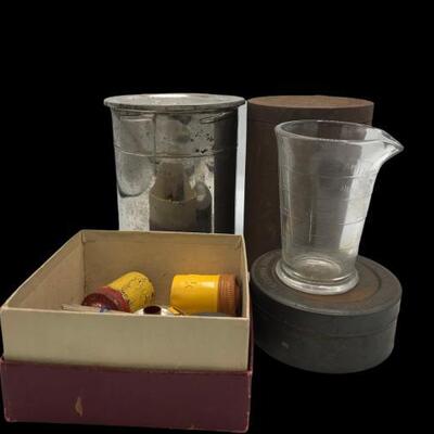 This lot contains a vintage film items that include. a silver film tank, metal film tank, slides and some old Kodak Film rolls....