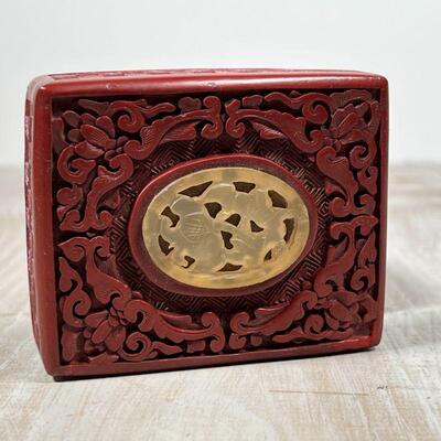CHINESE CINNABAR BOX | Carved cinnabar with a carved stone plaque, h. 1-3/4 x 3-3/4 x 2-3/4 in.
