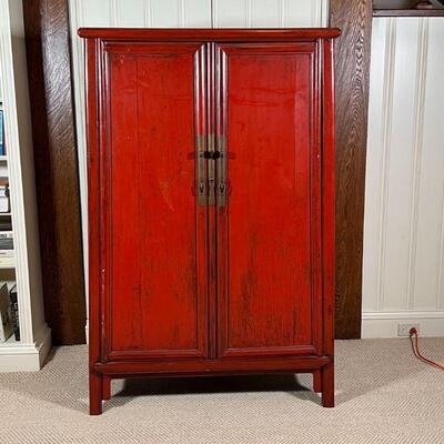 CHINESE LACQUERED CABINET | Red lacquered cabinet, with double doors opening to reveal two drawers between open shelves, with brass...