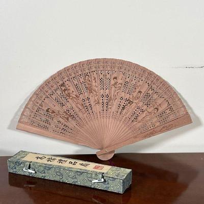 CHINESE WOOD FAN  |
Reticulated wood fan decorated with figures, in a silk box - l. 9 in.