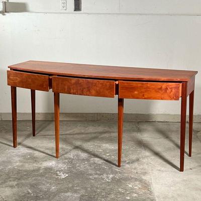 THOMAS MOSER SIDEBOARD  |  
Figured American cherry wood, having a bowed front with three drawers raised on six straight tapering legs -...
