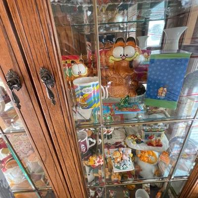 An entire curio cabinet full of Garfield collectibles as well as other cartoon characters 