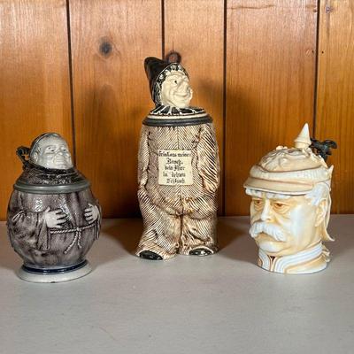 (3PC) GERMAN CHARACTER STEINS | Includes: (1) Kaiser Stein marked â€œMusterschutzâ€ (1) Monk Stein in stoneware. (1) Clown Stein marked...