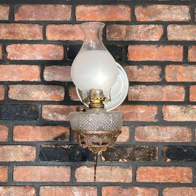 (2PC) BRACKET OIL LAMPS | Two 19th C Iron Bracket Oil Lamps: (1) Large Ornate Iron Bracket painted black with oil lamp and chimney....