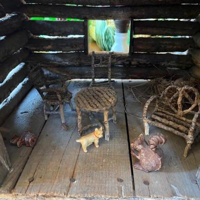 1920s folk art log cabin with furniture and wooden animals