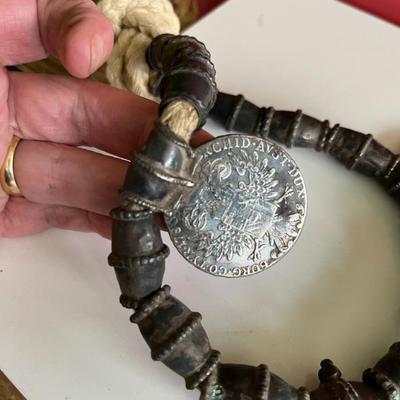 Omani silver pendant on a necklace with large silver beads and two 18th century coins on a thick cord