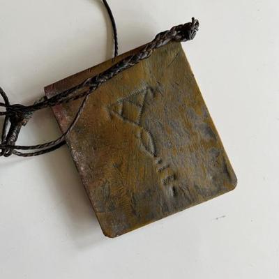 North African brass pendant with geometric designs and a shackled jinn