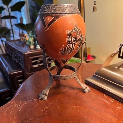 decorated South American gourd with a silver collar on a stand