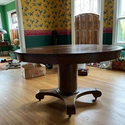 Late 19th century oak pedestal table with two leaves, goes from round to oval, solid wood