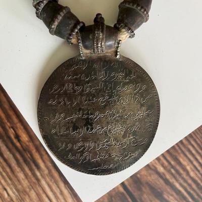 Omani silver pendant on a necklace with large silver beads and two 18th century coins on a thick cord