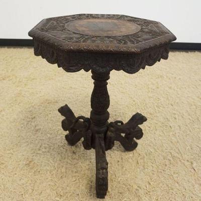 1136	HEAVILY CARVED ASIAN TABLE WITH OCTAGON TOP AND CARVED LION LEGS, APPROXIMATELY 20 IN X 27 IN H
