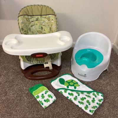 Lot #126 - Fisher Price Space Saver Highchair, Summer Infant potty seat, & Carter’s turtle-themed wash cloth and towel set.