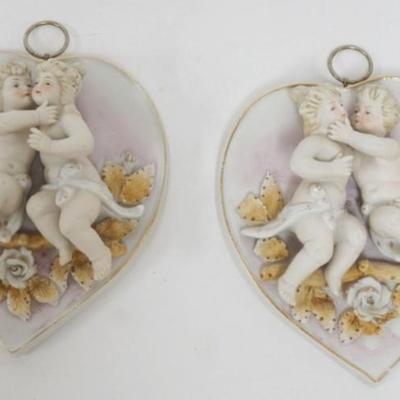 1122	PAIR OF AMART BISQUE HEART SHAPED WALL PLAQUES WITH KISSING CHERUBS MOUNTED ON TOP. EACH APPROXIMATELY 6 IN X 5 IN 
