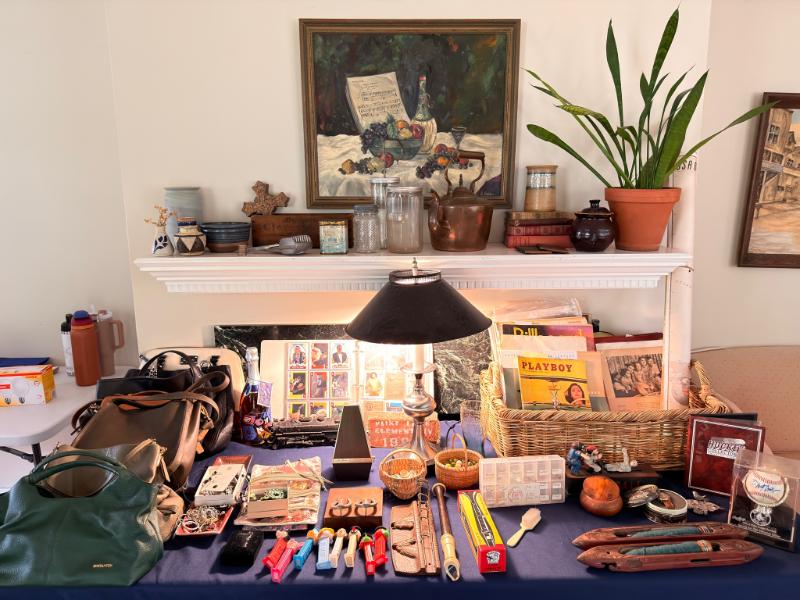 Staged table of collectibles and art at an Estate Greats sale in Belle Meade, Tennessee