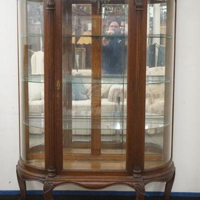 1230	ORNATE OAK CHINA CABINET WITH BEVELED GLASS DOOR AND CURVED SIDES, HAVING A SHELL CARVED CREST AND REEDED COLUMN SIDES ON BALL AND...