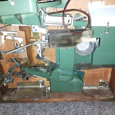 Sale Photo Thumbnail #2: A vintage mechanical Nishijin pachinko machine housed in a wooden frame. Features colorful playfield graphics, chrome accents, and mechanical internal components visible from the rear. Includes a small orange tray containing steel pachinko balls.