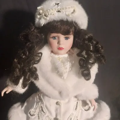 Sale Photo Thumbnail #451: MEASURES 16" TALL AND COMES WITH STAND. WINTER THEMED OUTFIT WITH FUR TRIMMED COAT, MATCHING HAT AND PEARL LIKE ACCENTS