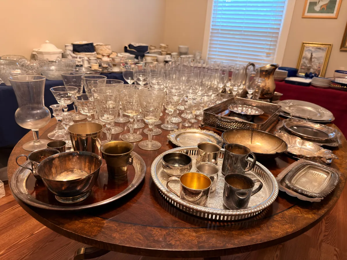 Table of crystal stemware and silver at an Estate Greats sale in Franklin, Tennessee