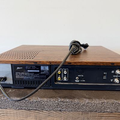 Sale Photo Thumbnail #23: Vintage Zenith 4-Head VHS HQ video cassette recorder (VCR), model VR 1825. Features a simulated wood grain cabinet, front drop-down control panel with timer programming instructions, RCA video/audio inputs and outputs, and coaxial antenna connections. Ser