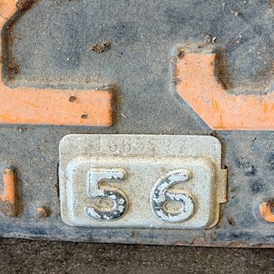 Sale Photo Thumbnail #41: Matching pair of vintage 1956 New Jersey metal license plates, registration number ZA 23F. Each plate features embossed orange characters on a dark background with an attached metal '56' tab (stamped 1665727). Both plates show significant age, surface rus
