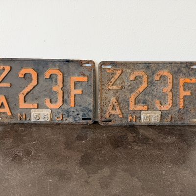 Sale Photo Thumbnail #39: Matching pair of vintage 1956 New Jersey metal license plates, registration number ZA 23F. Each plate features embossed orange characters on a dark background with an attached metal '56' tab (stamped 1665727). Both plates show significant age, surface rus