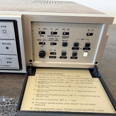 Sale Photo Thumbnail #19: Vintage Zenith 4-Head VHS HQ video cassette recorder (VCR), model VR 1825. Features a simulated wood grain cabinet, front drop-down control panel with timer programming instructions, RCA video/audio inputs and outputs, and coaxial antenna connections. Ser