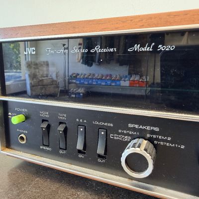 Sale Photo Thumbnail #5: Vintage JVC Model 5020 FM/AM stereo receiver featuring a built-in S.E.A. equalizer control system. Encased in a wood cabinet with a black front panel, illuminated green tuner display, and brushed metal accent trim. Manufactured by Victor Co. of Japan, Ltd