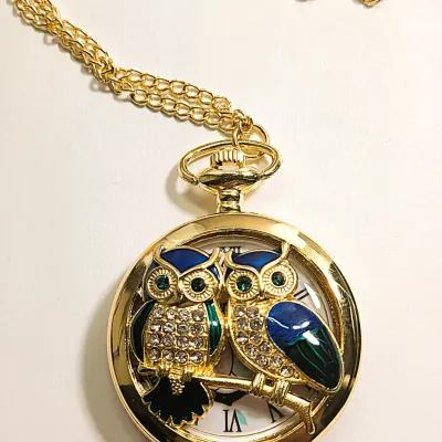 Sale Photo Thumbnail #5: Very Cute OWL POCKET WATCH with Blue/Green Feathers & Green Eyes, Gold Tone Setting and 30" L Chain/Lobster Clasp**EXTRA BATTERY INCLUDED**

QUARTZ
Non-rechargeable Battery
Brand: ALPHYNIX
Case Shape & Type: Round & Gold Colored
Display: Analog
Feature: S
