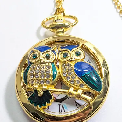 Sale Photo Thumbnail #4: Very Cute OWL POCKET WATCH with Blue/Green Feathers & Green Eyes, Gold Tone Setting and 30" L Chain/Lobster Clasp**EXTRA BATTERY INCLUDED**

QUARTZ
Non-rechargeable Battery
Brand: ALPHYNIX
Case Shape & Type: Round & Gold Colored
Display: Analog
Feature: S