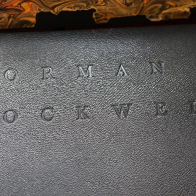 Exceptional leather bound large book in jacket that has many illustrations  and history of Norman Rockwell 