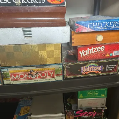 Collection of vintage and classic board games, including Chinese Checkers, Yahtzee, Monopoly Deluxe Edition, Trivial Pursuit, and Domino...