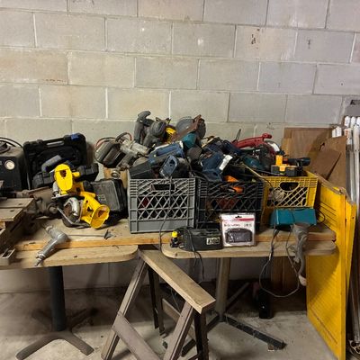 Large assortment of power tools and shop equipment, including drills, saws, milk crates of accessories, and a bench vise, shown in used...