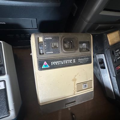 Vintage Kodak Partytime II Kodamatic instant camera, featuring a tan and brown plastic body with lighten/darken control slider, circa...