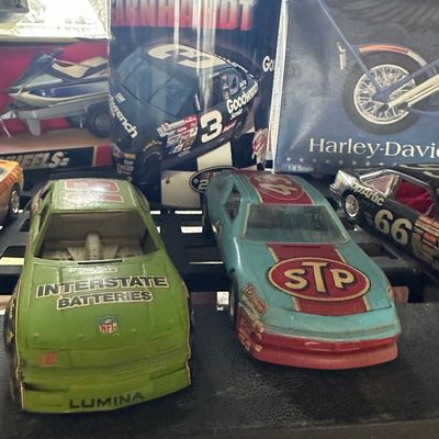 Vintage NASCAR collectibles, including vintage toy stock cars and a Dale Earnhardt Sr. collectible tin canister.